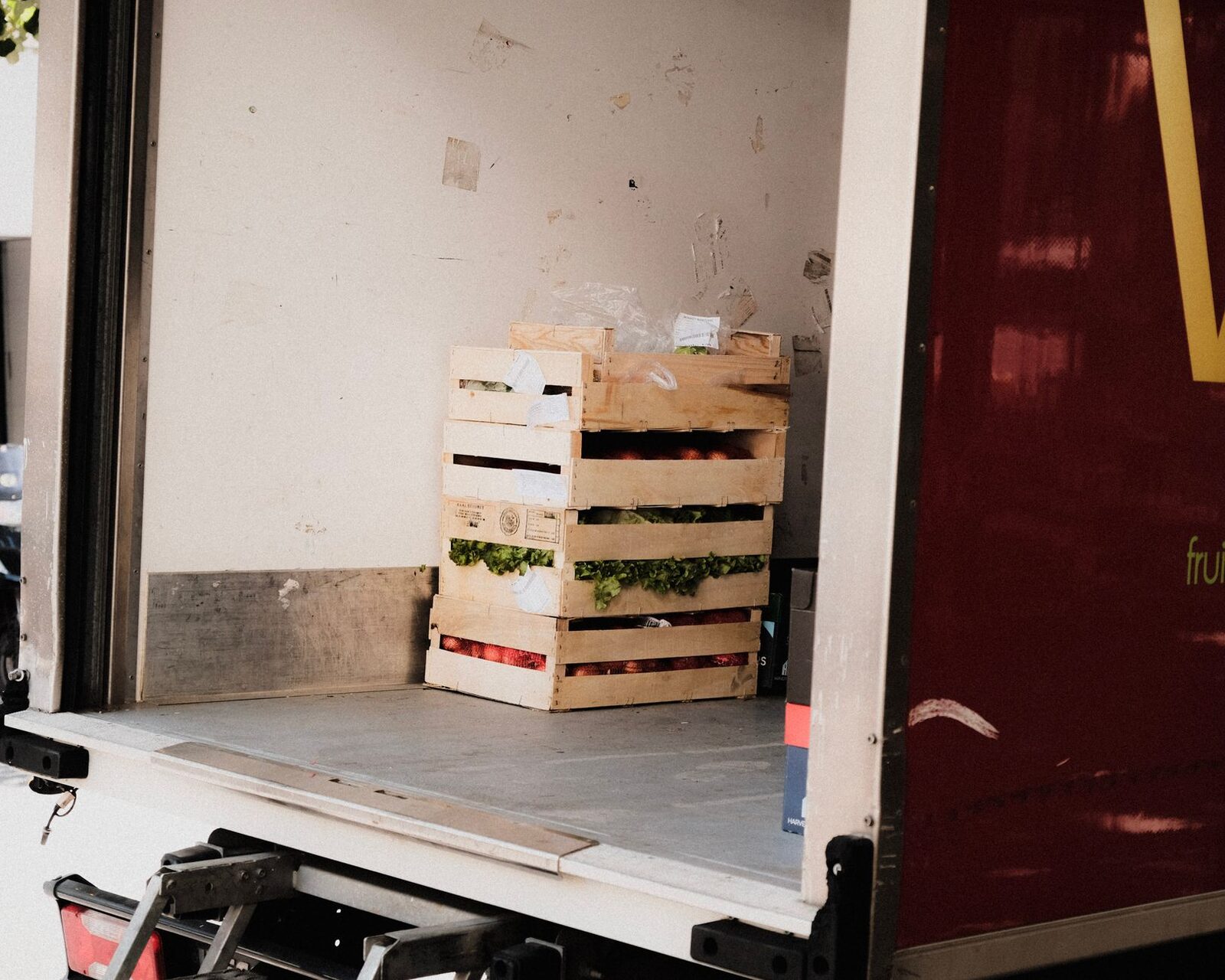 A small farm vendor unloads fresh produce crates at a regional food hub loading dock