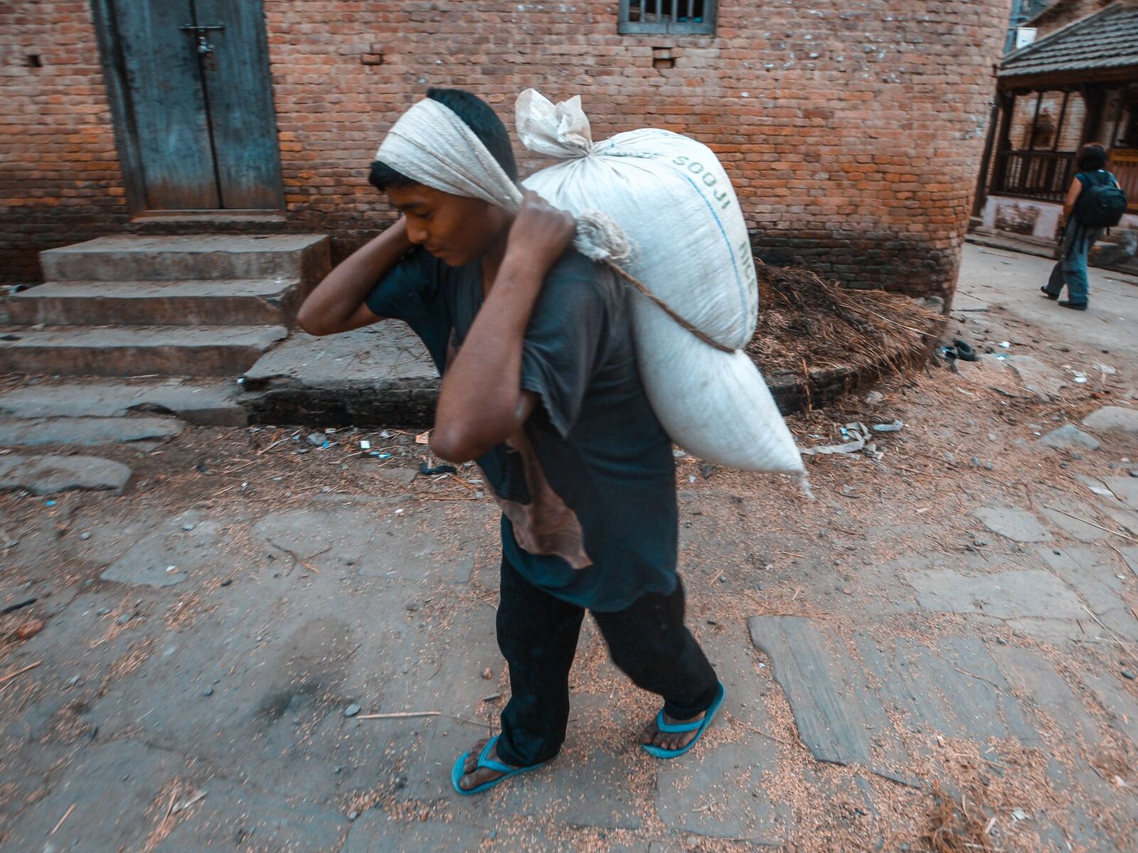 A field worker under a bright sun, tools in hand