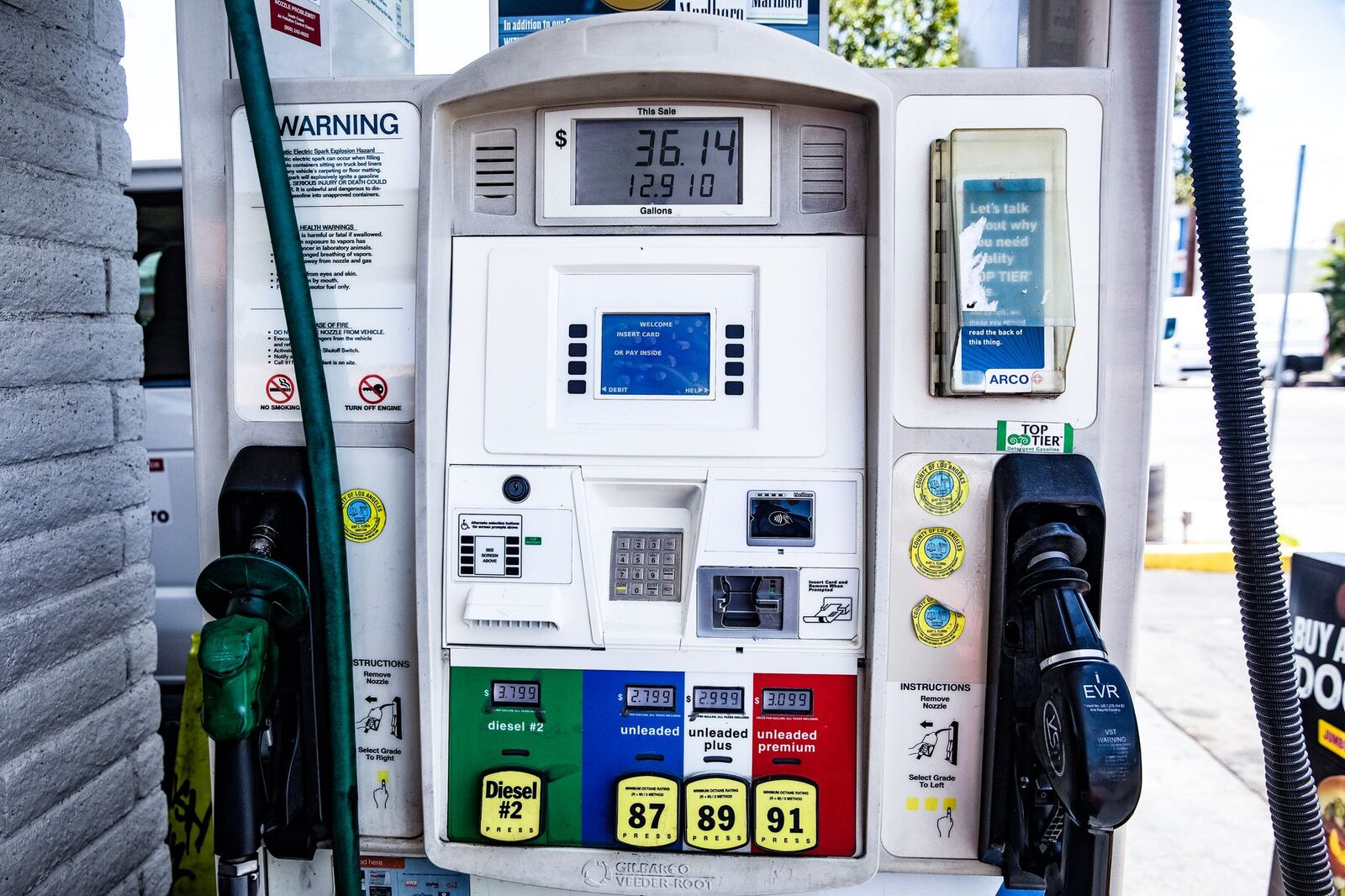 A farm tractor filling up with diesel fuel at a rural pump