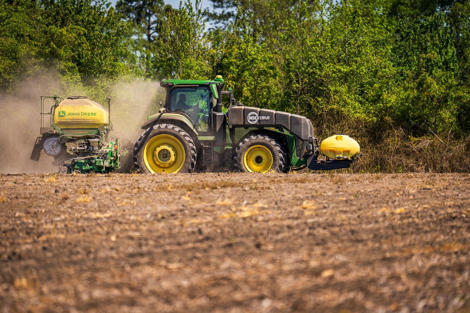 A green John Deere tractor in a field